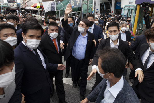 범(汎)야권 대선주자인 윤석열 전 검찰총장이 20일 오후 대구 중구 서문시장을 찾은 자리에서 지지자들에게 손을 들어 인사하고 있다.연합뉴스